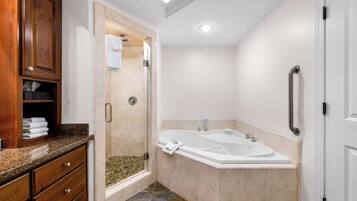 Une salle de bain moderne dotée d’une douche à l’italienne, d’une baignoire sur pieds et de meubles en bois.