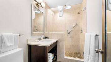 A modern bathroom with a sink, mirror, and shower.