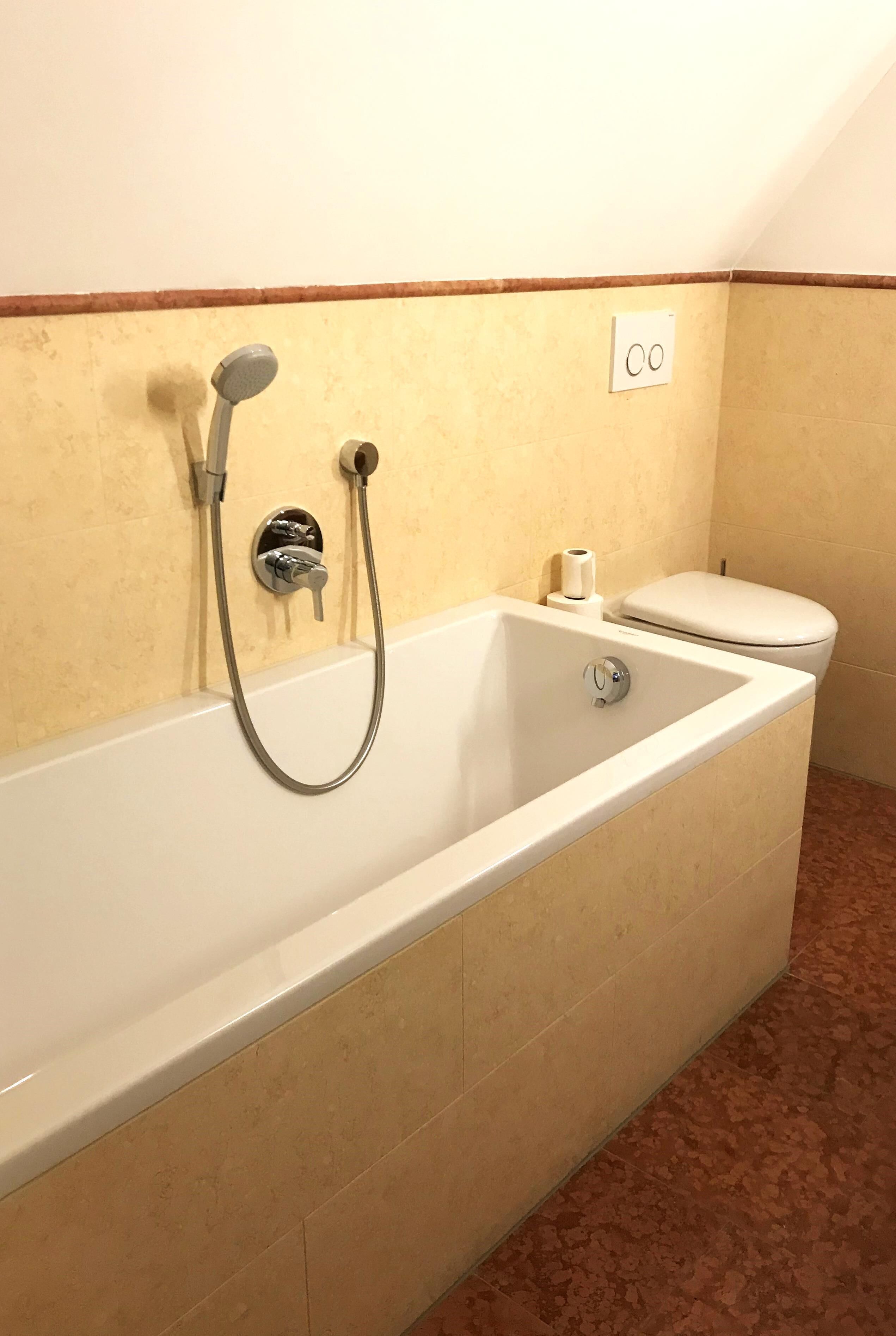 A standard hotel bathroom with a bathtub, a toilet, and a shower.