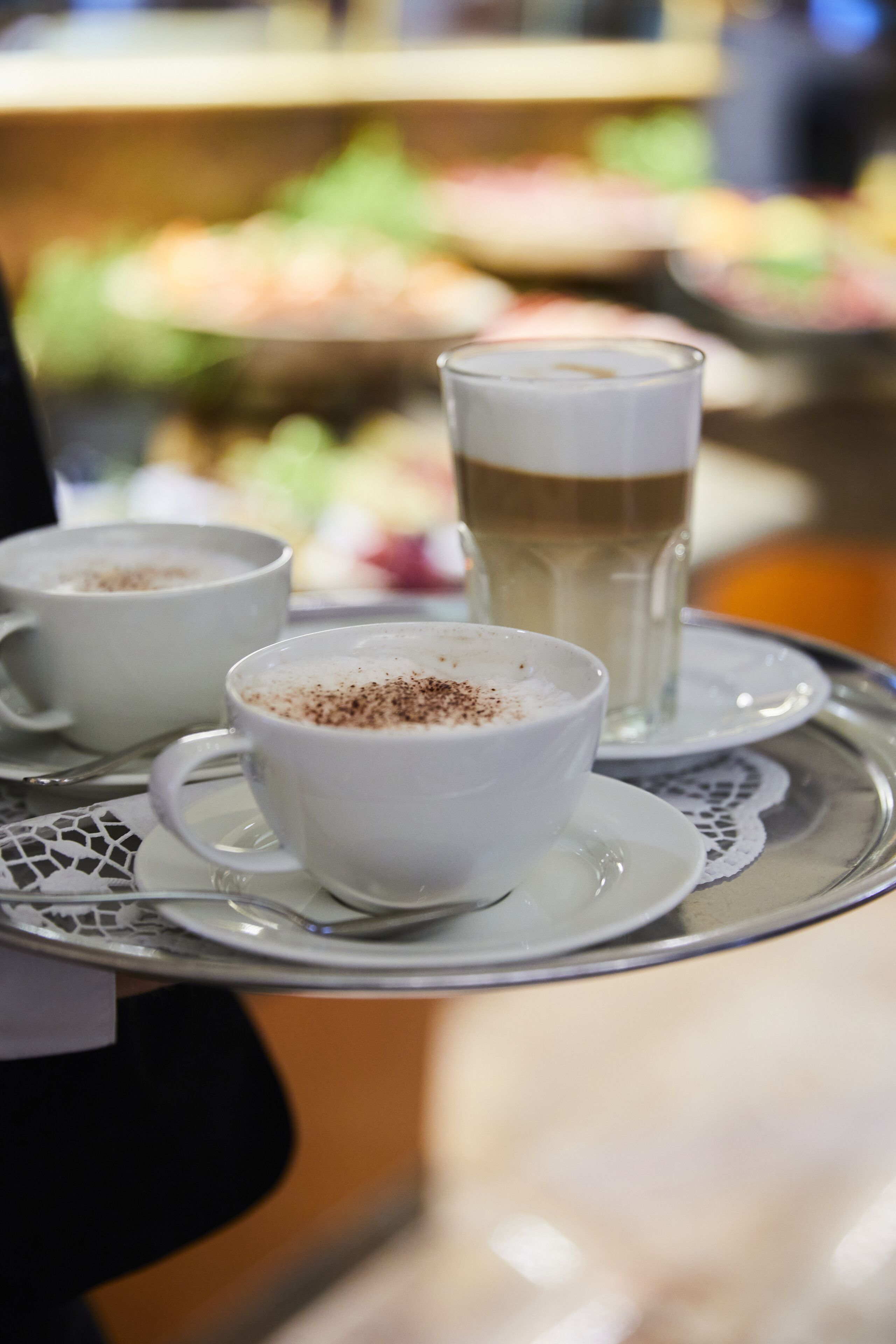 Una bandeja con dos tazas de café y un vaso de latte.