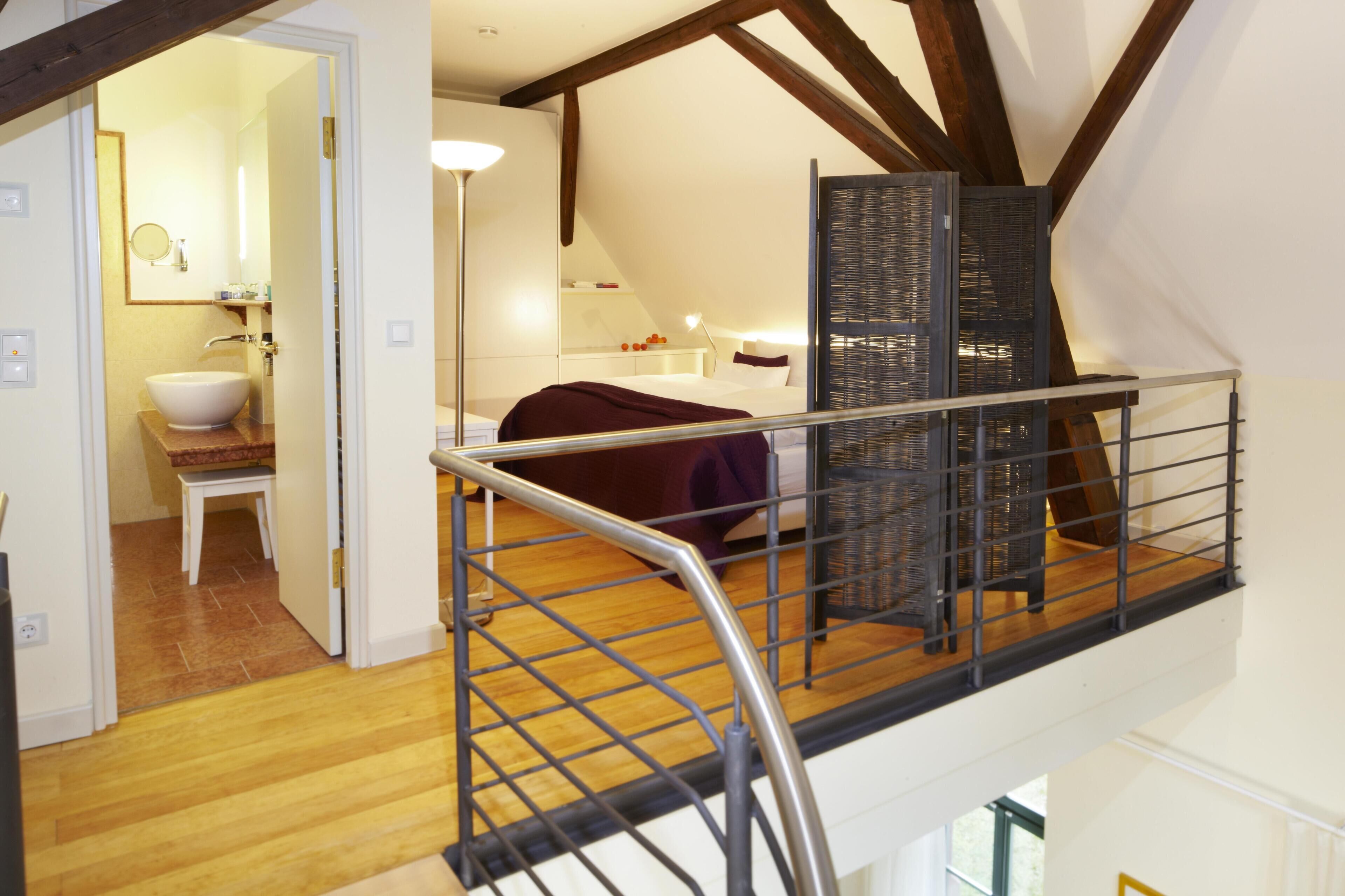 Une chambre à coucher avec un lit, une table de chevet, une lampe et une fenêtre avec des stores.