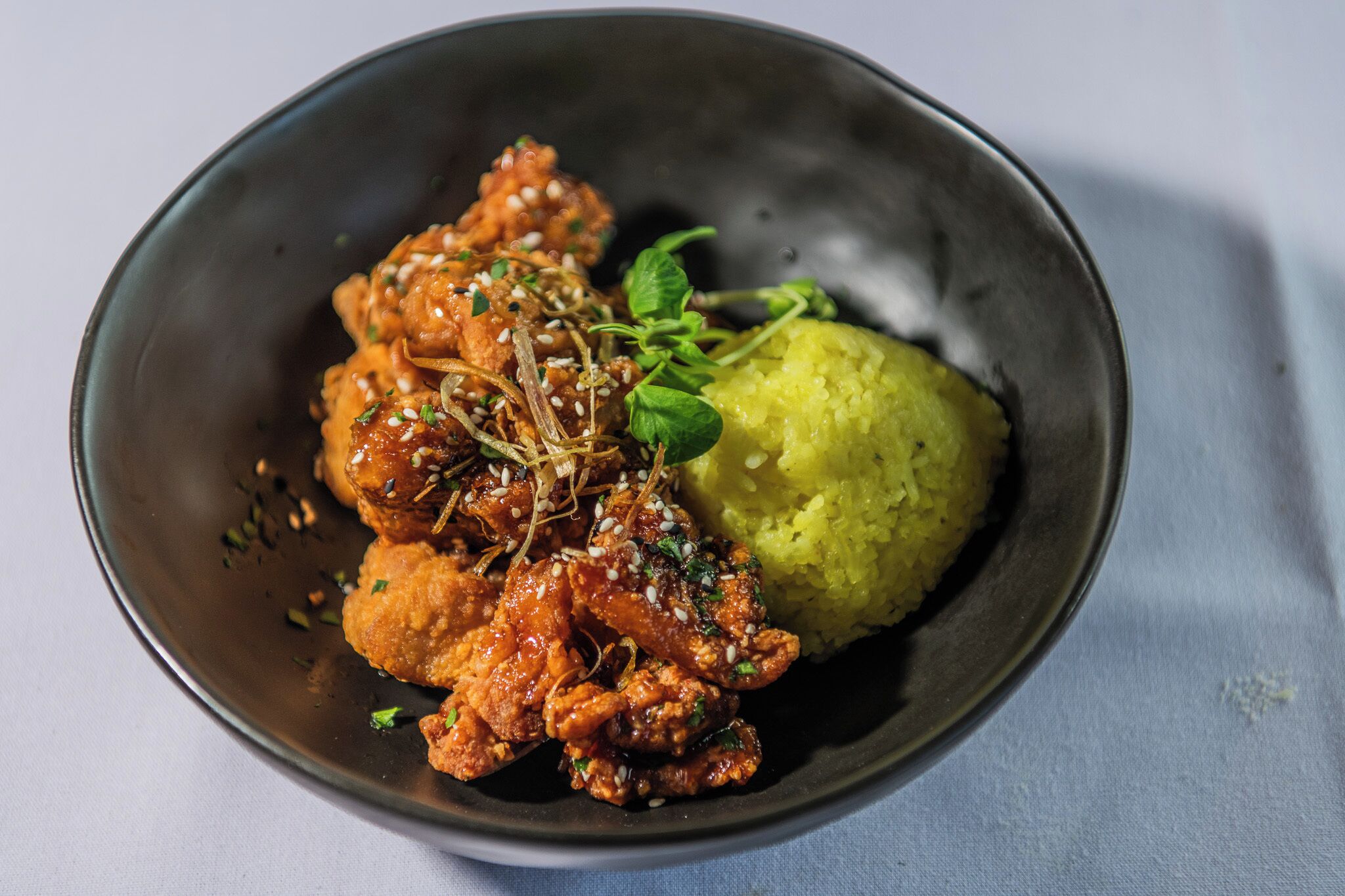 A bowl of food with a side of rice.