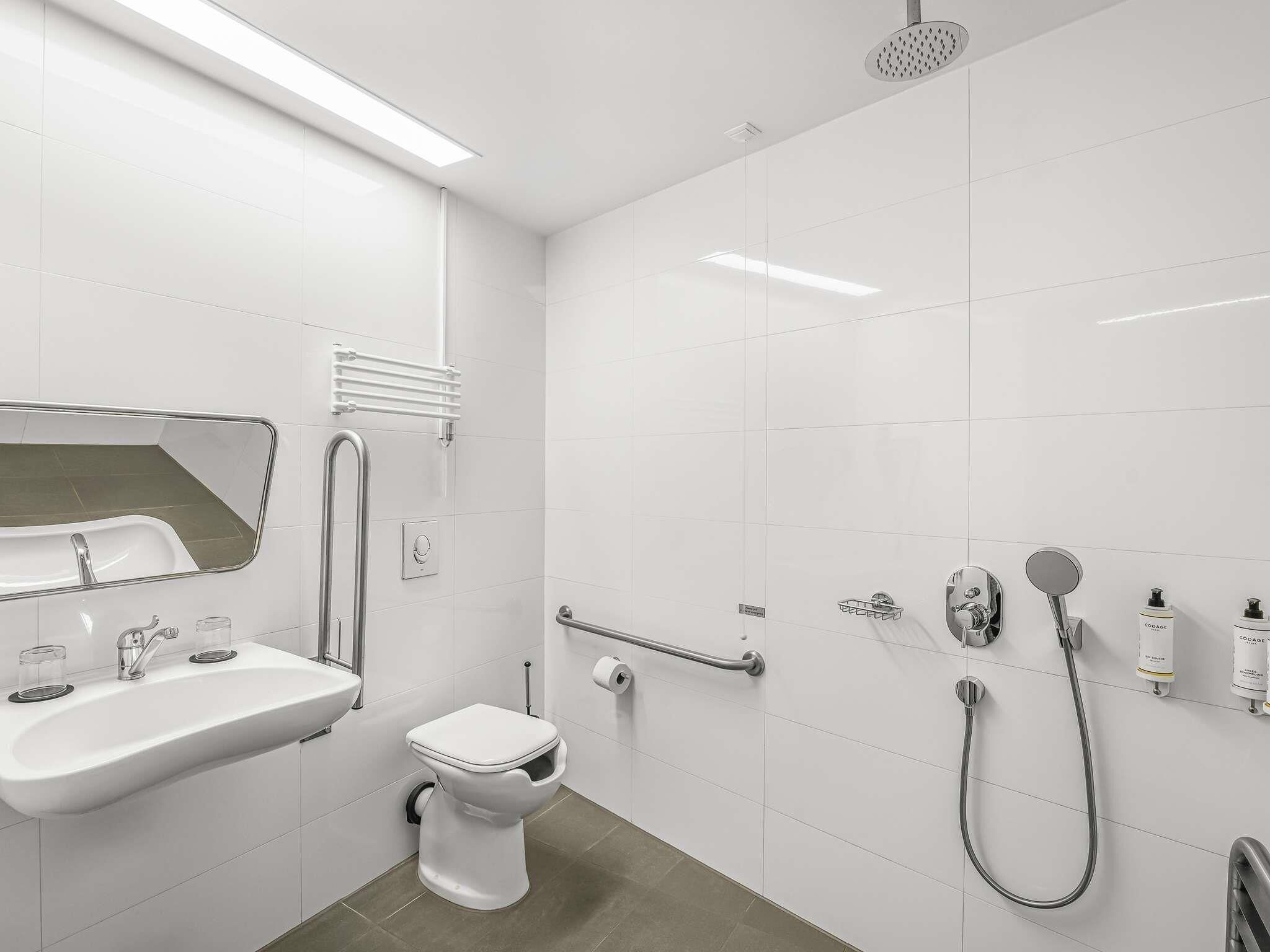 Une salle de bain moderne avec un lavabo, des toilettes et une douche.