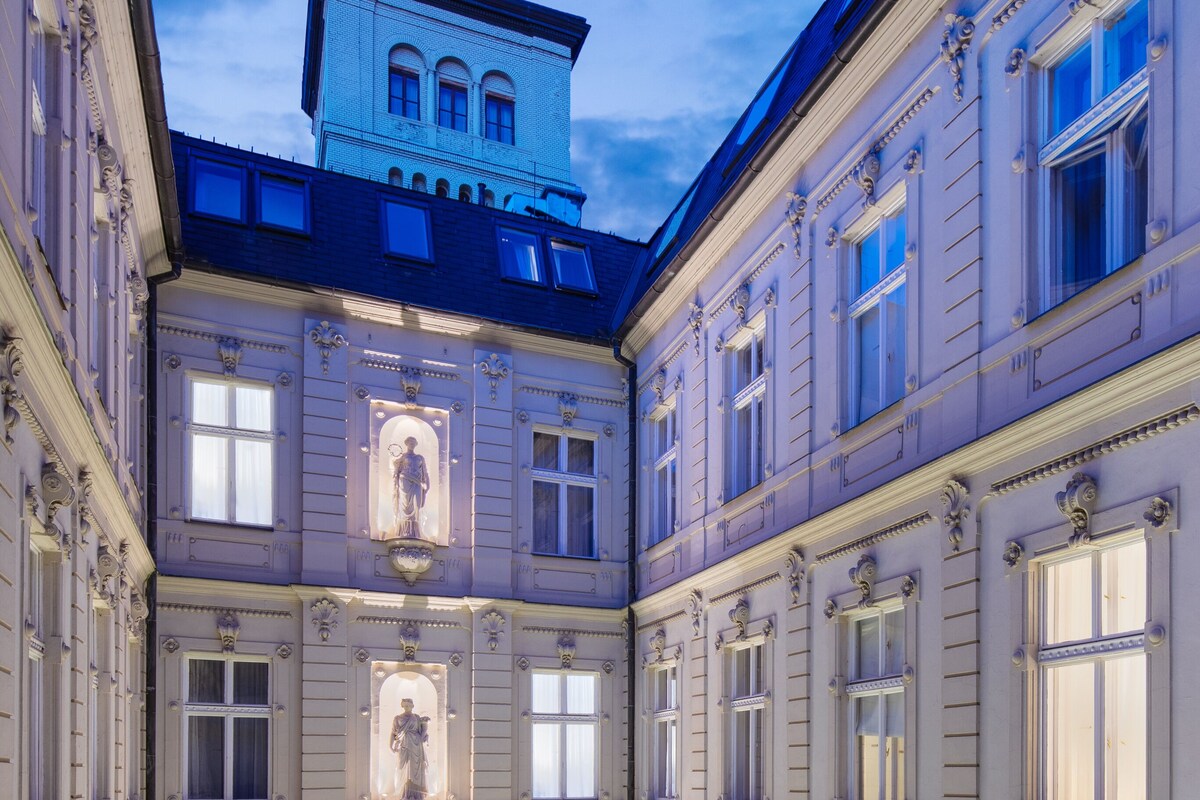 A multi-story building with ornate architectural details, including statues and decorative moldings.