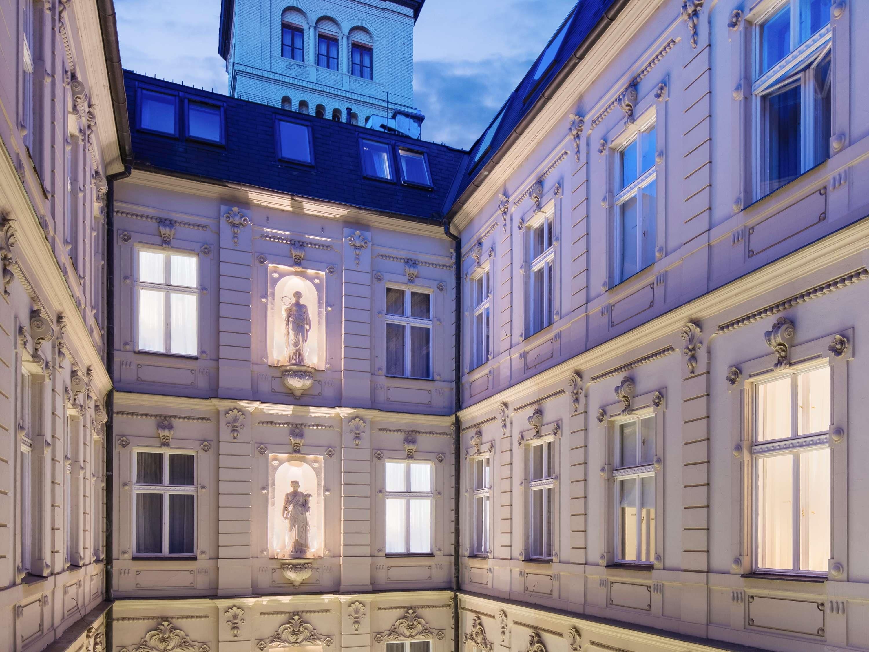 A courtyard with ornate architecture, including statues and decorative moldings.