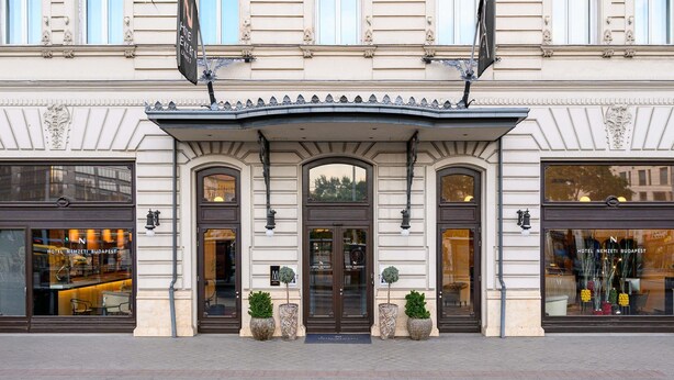 A historic building with ornate architecture, large windows, and a central entrance with a decorative pediment.