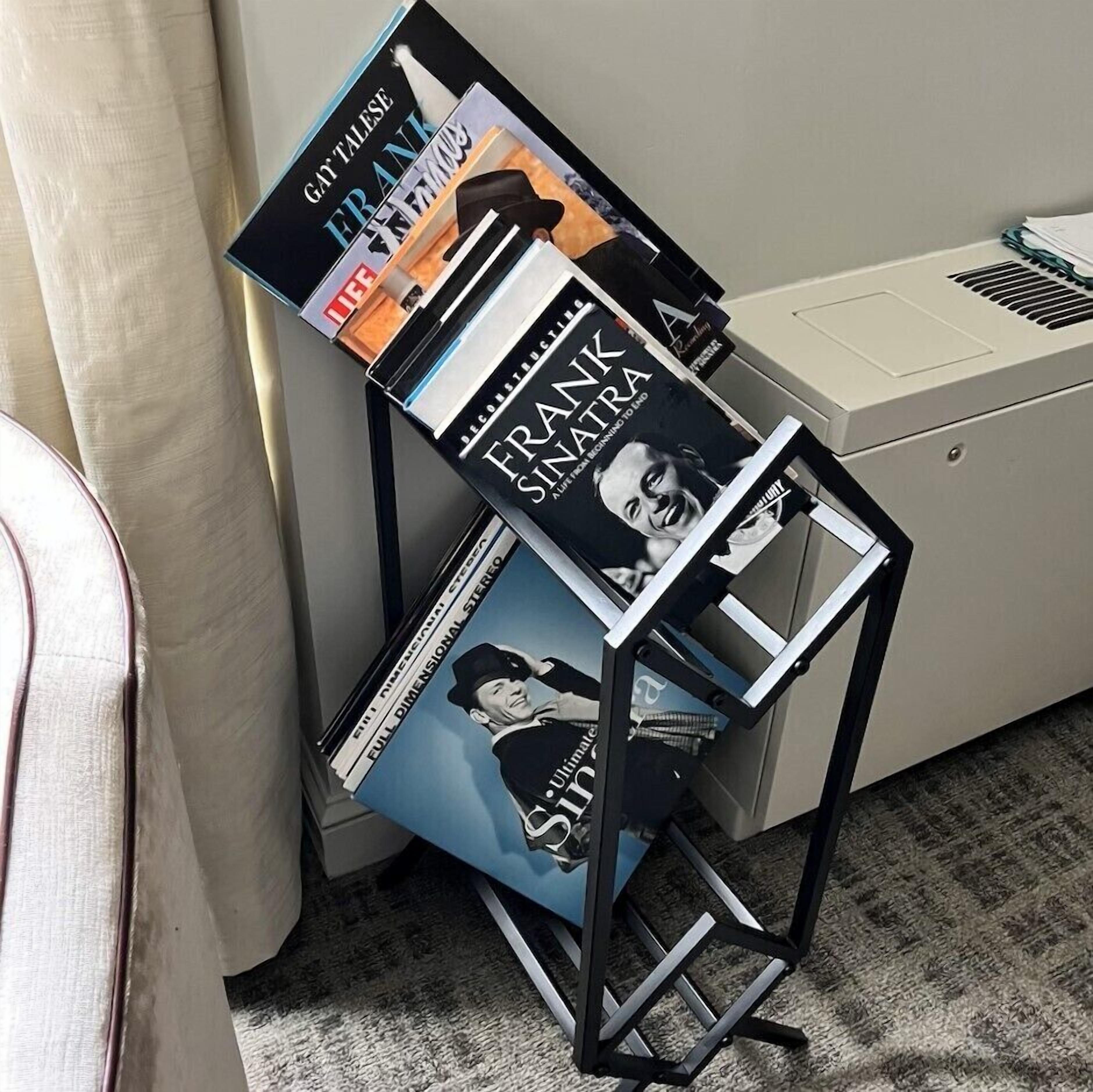 A music stand with vinyl records and a printer.