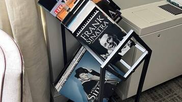 A music stand with vinyl records and a printer.