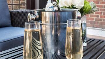 A table with two champagne glasses and a champagne bucket with flowers.