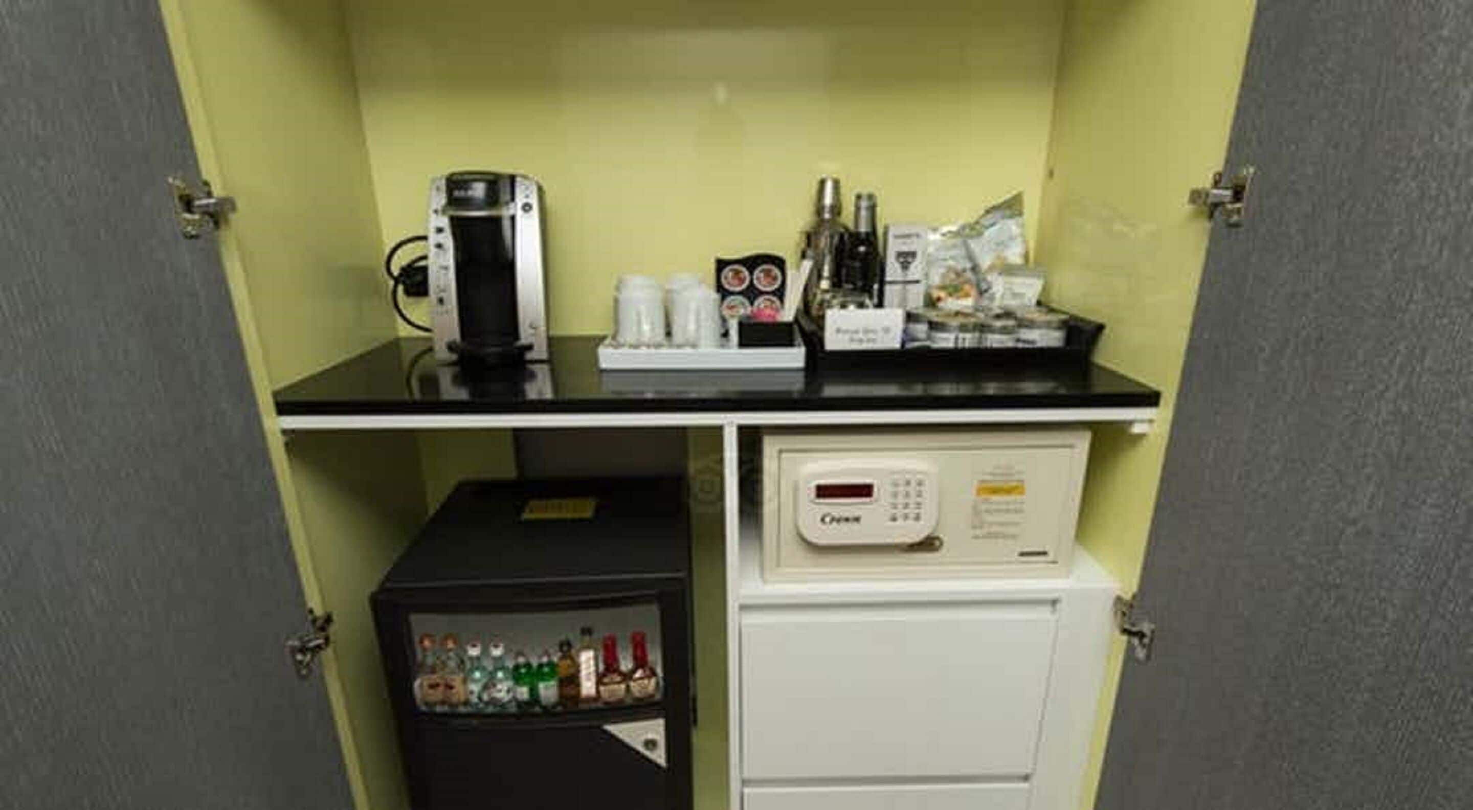 A kitchenette with a coffee maker, a mini-fridge, and a microwave.