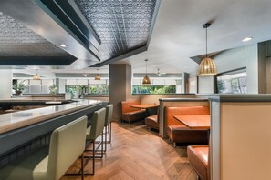 Un interior moderno con barra, asientos y ventanas amplias.
