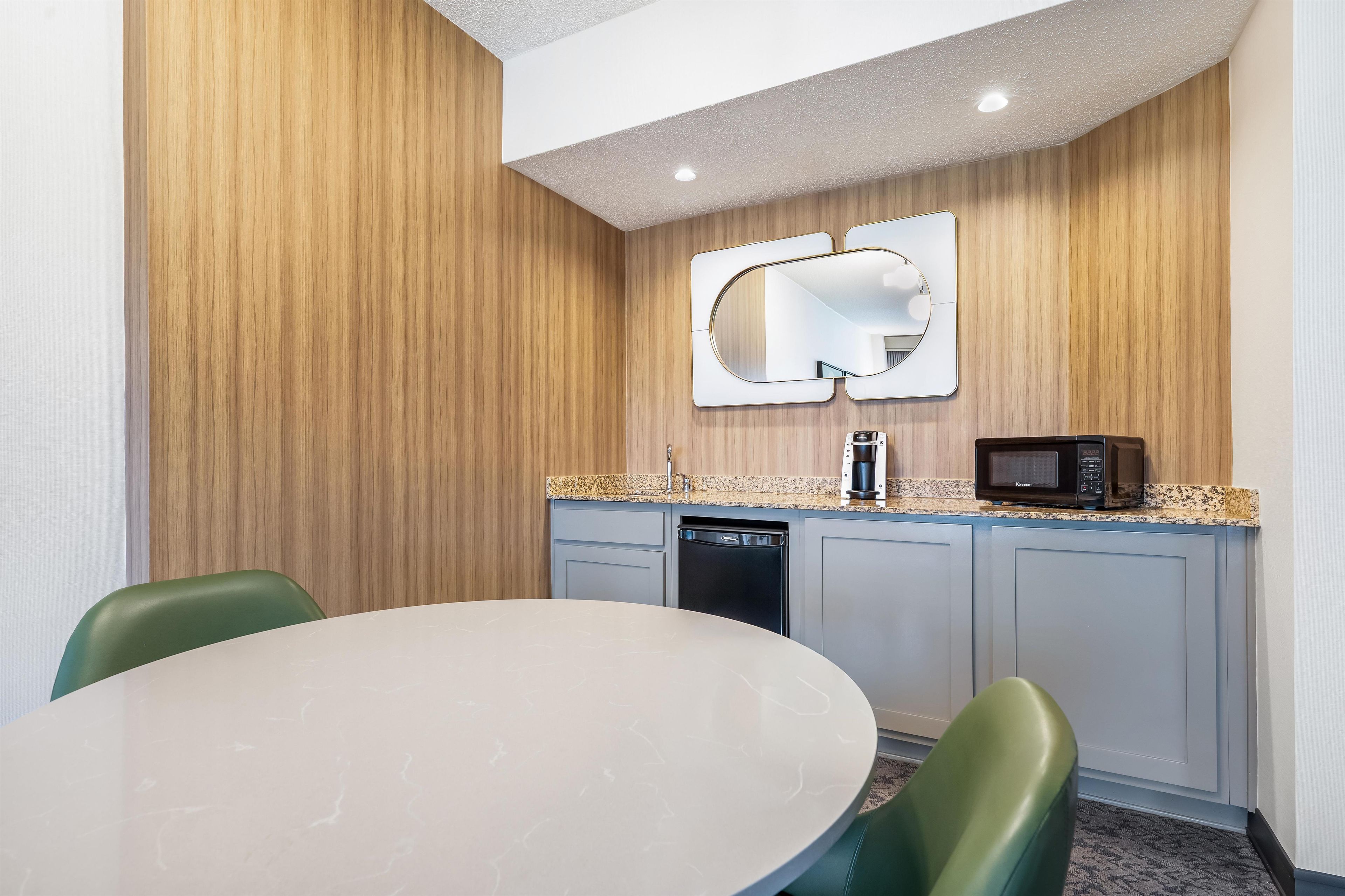 Una cocina moderna con una mesa de comedor redonda, un microondas y un lavavajillas.