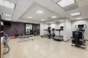 A gym with various exercise equipment, including treadmills, stationary bikes, and weight machines. - DoubleTree Suites by Hilton Raleigh - Durham (Durham)