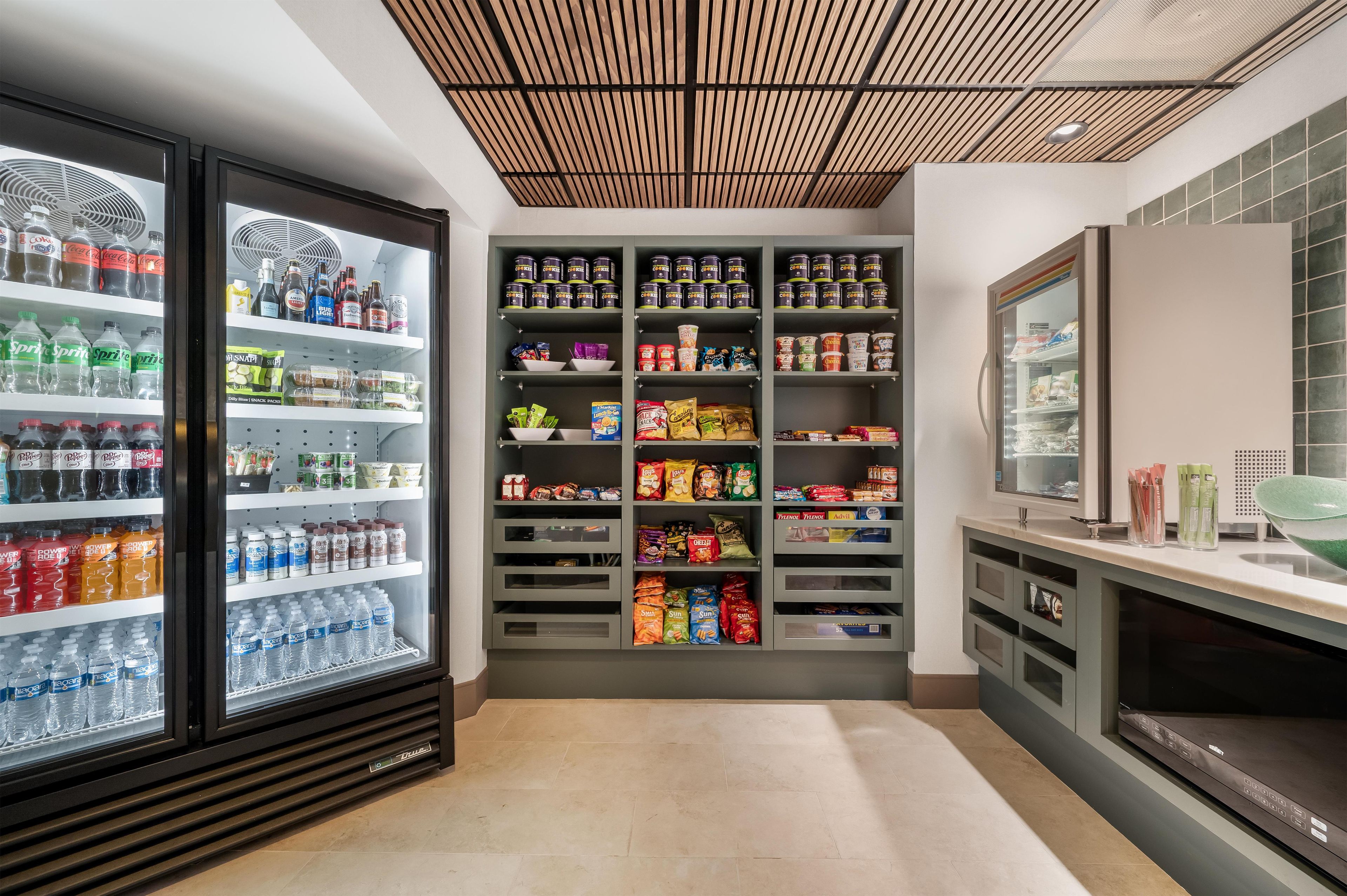 A well-stocked beverage fridge with various drinks, a snack section with chips and cookies, and a small refrigerator with condiments.