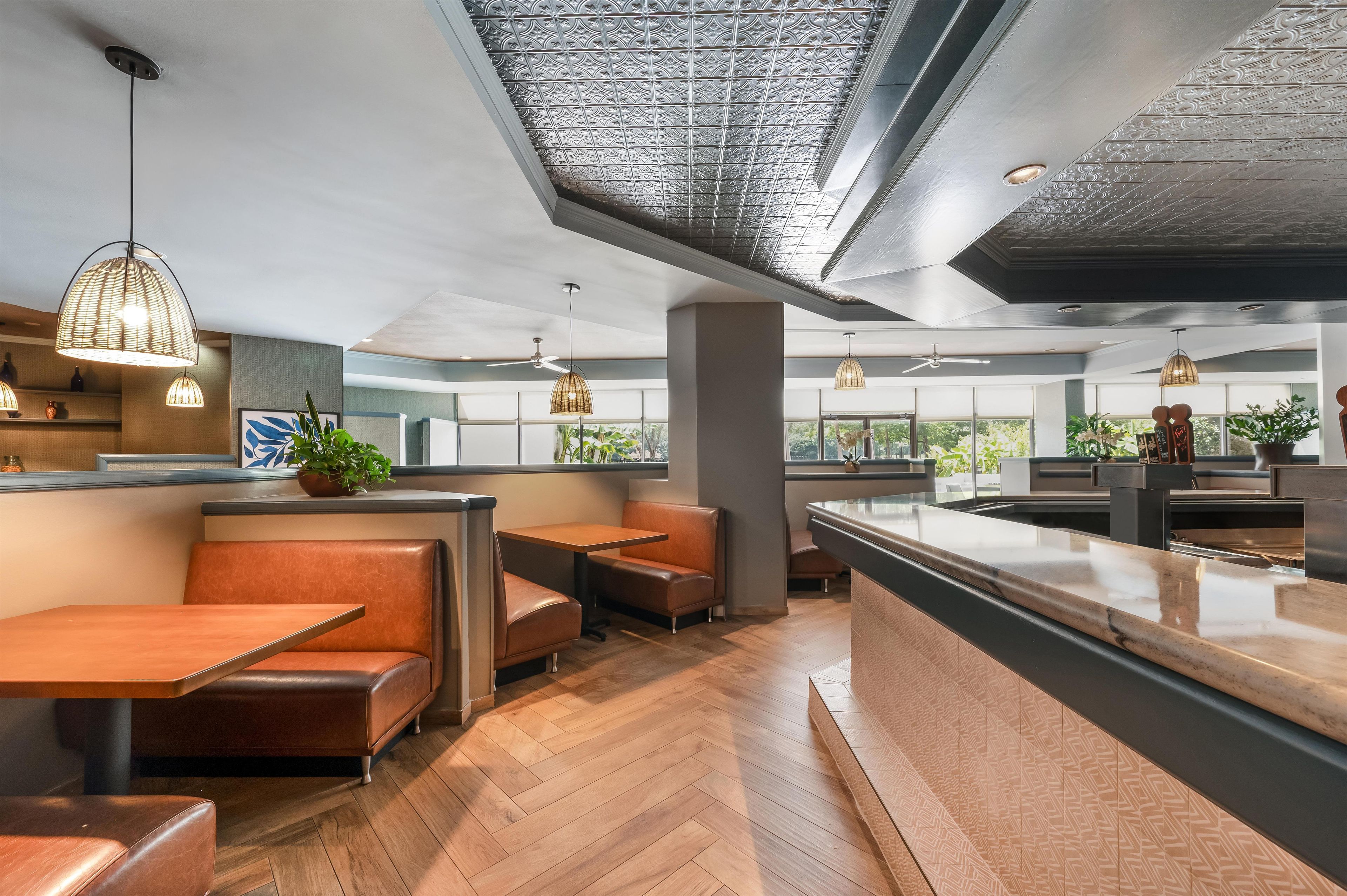 A modern interior with wooden flooring, leather seating, and pendant lighting.