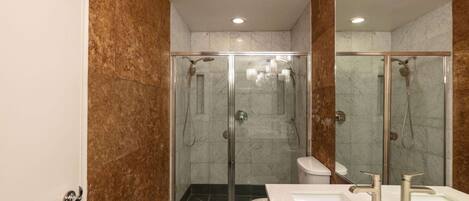 Une salle de bain moderne avec une douche à parois de verre, un lavabo blanc et des toilettes.