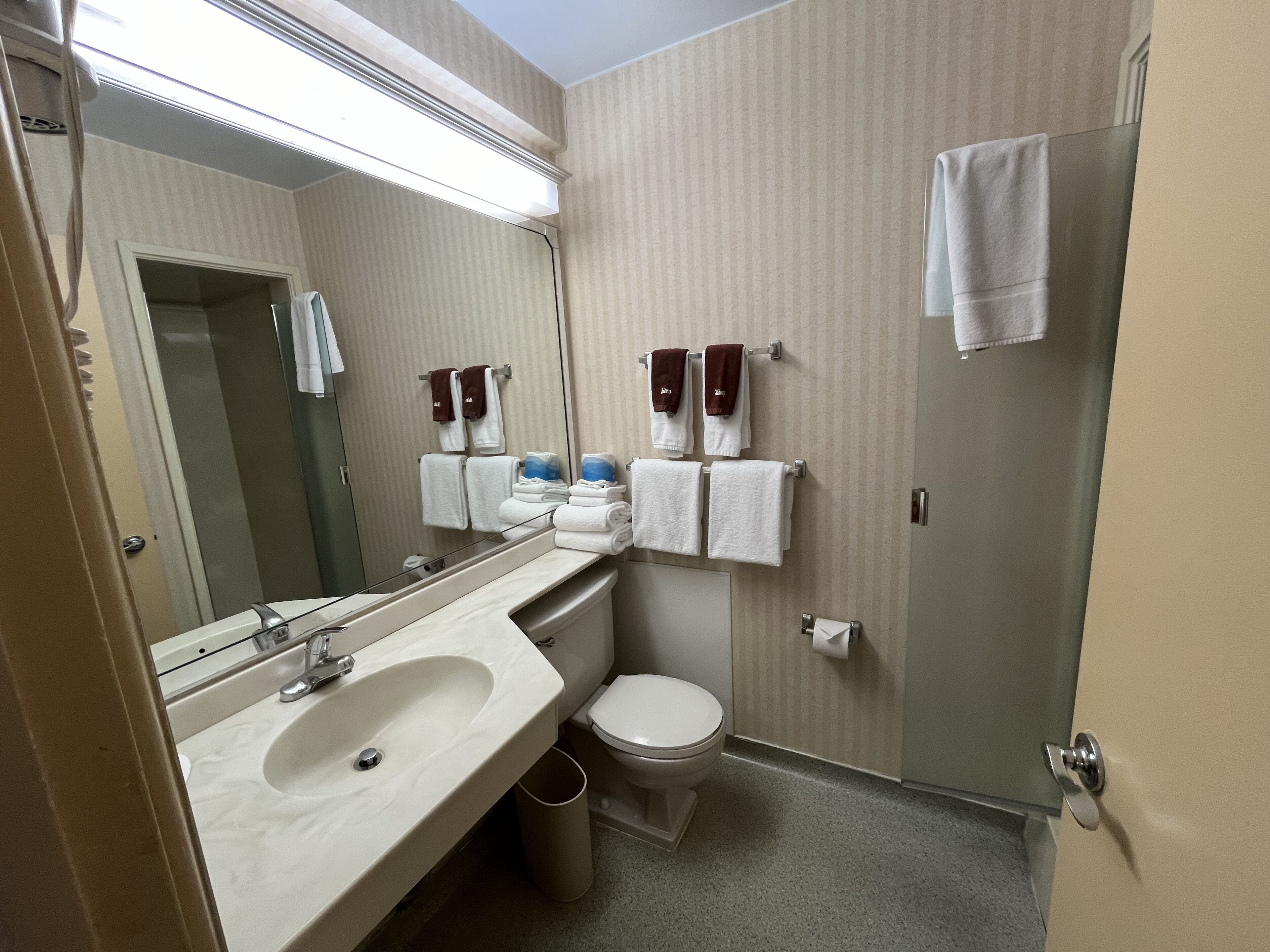 A bathroom with a sink, toilet, and towel rack.
