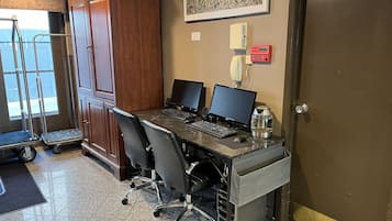 Una sala de conferencias con dos escritorios, sillas, una cafetera y una cámara de seguridad.