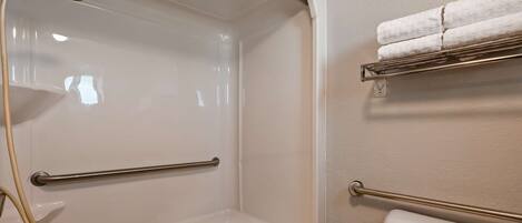 A bathroom with a shower, toilet, and towel rack.