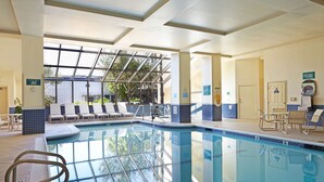A swimming pool with lounge chairs and a glass-enclosed area. - Embassy Suites by Hilton Los Angeles International Airport North (Los Angeles)