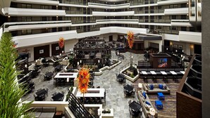 A multi-level hotel atrium with outdoor seating areas, a central lounge, and multiple balconies. - Embassy Suites by Hilton Los Angeles International Airport North (Los Angeles)