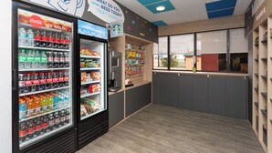 Una moderna area ristoro pulita, con diverse opzioni per bevande e una macchina per caffè.