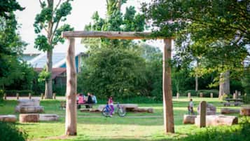 Relax in a serene outdoor setting surrounded by lush greenery and shaded by a pergola.