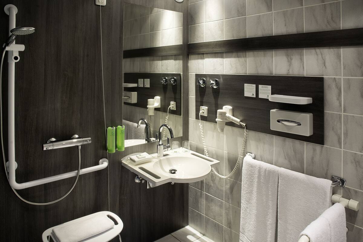 A modern bathroom with a shower, sink, and toilet.