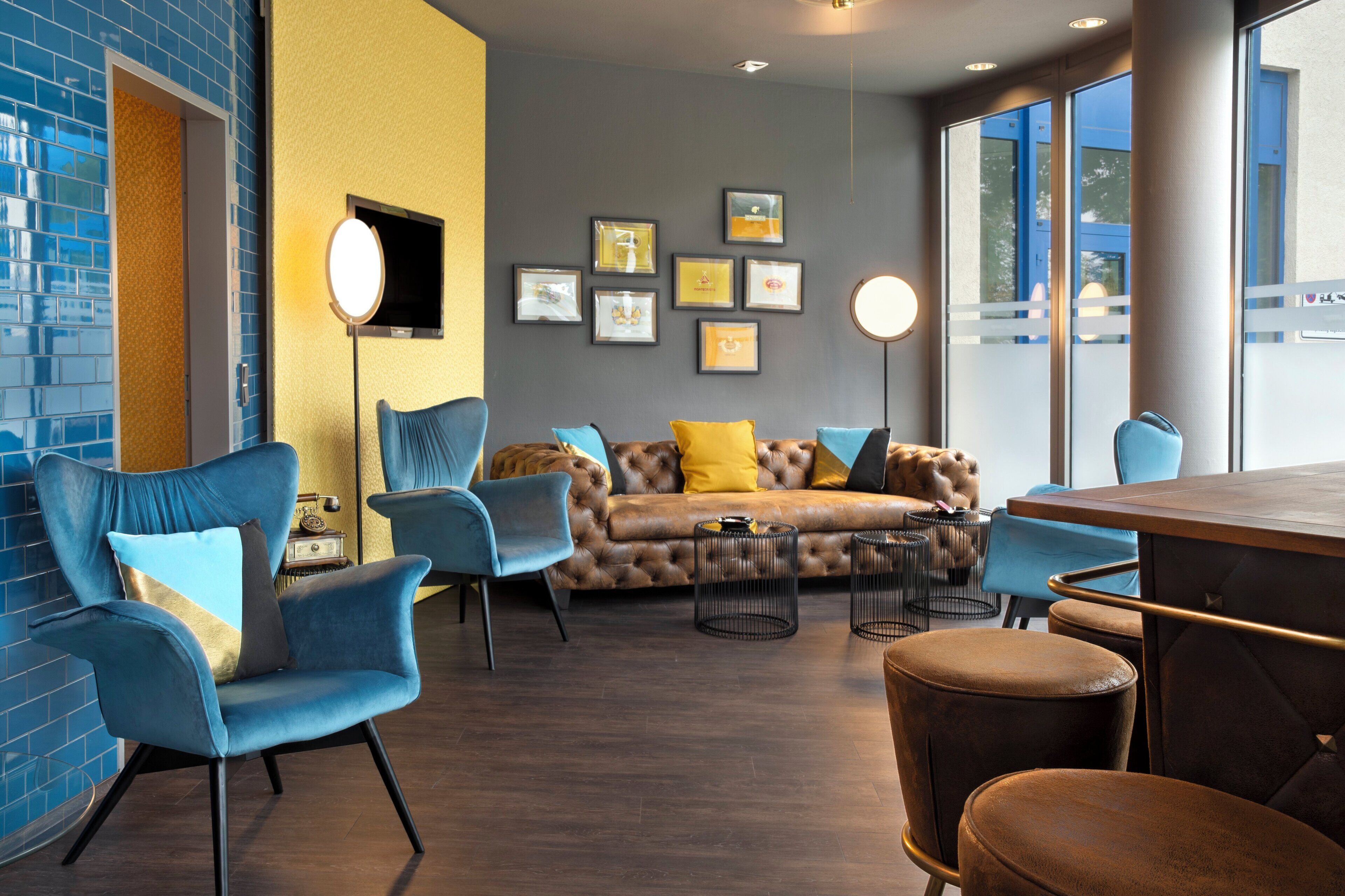 A modern lounge area with a sofa, chairs, and a bar.