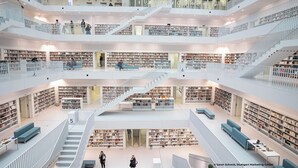 A multi-level library with bookshelves, seating areas, and staircases. - Holiday Inn Stuttgart by IHG (Stuttgart)