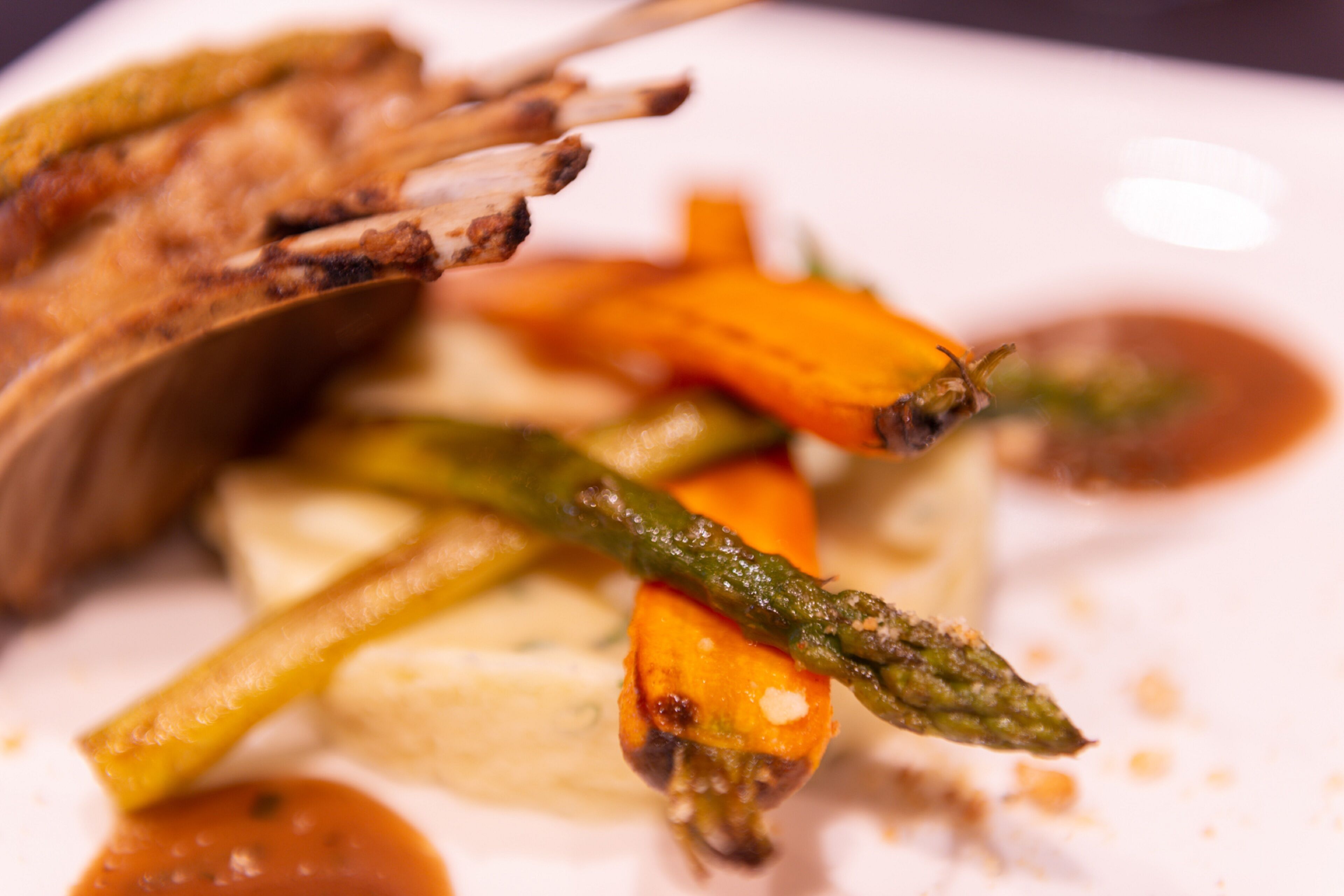 A plate of food with grilled meat, carrots, and asparagus.