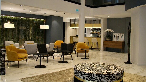 A modern lobby with seating areas, a bar, and a reception desk. - Hôtel l'Amirauté (Brest)