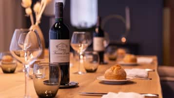 A table set with wine glasses, a bottle of wine, and pastries.