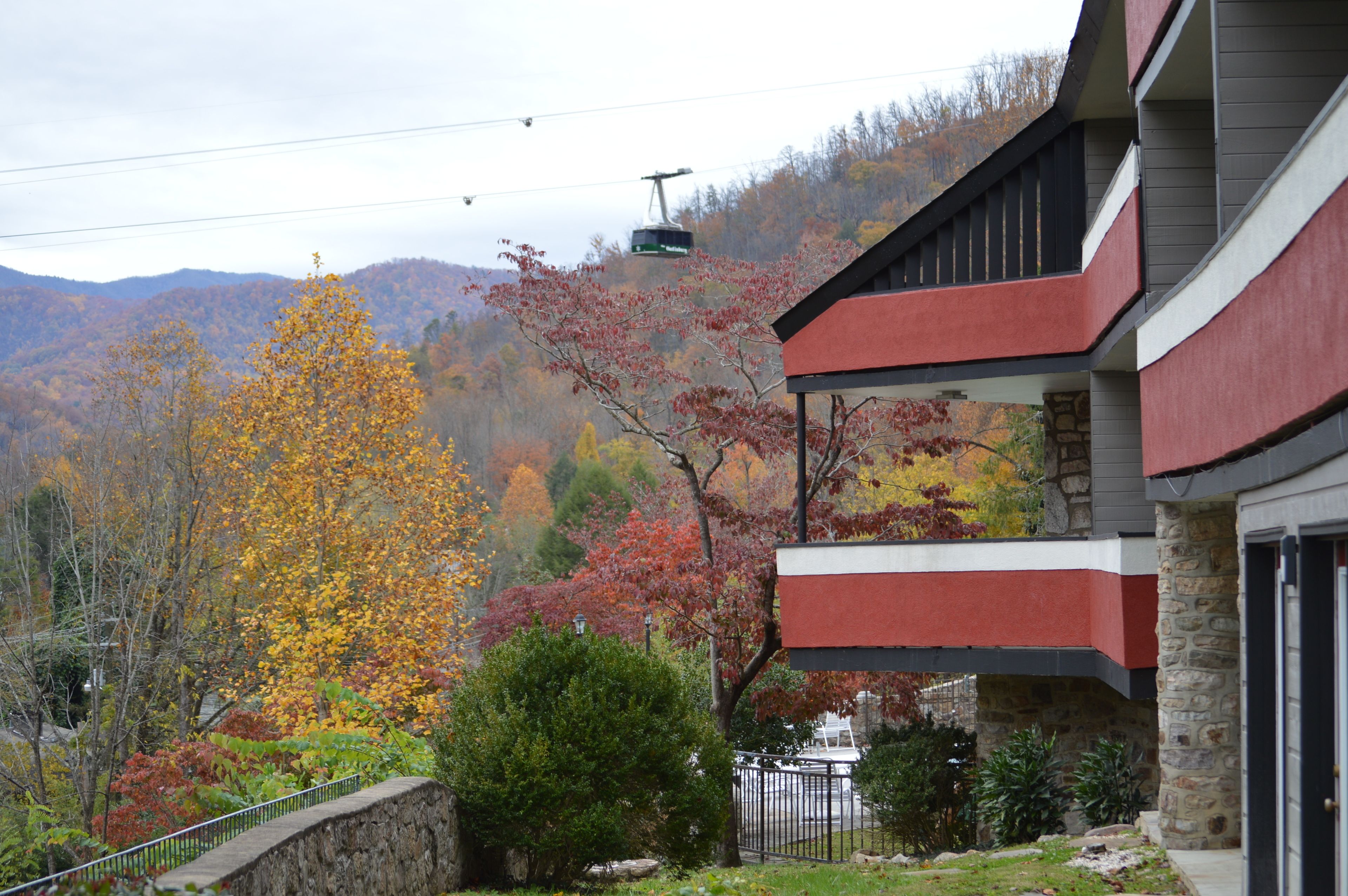 A two-story building with a stone foundation and a red and gray facade.