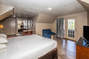 Una habitación de hotel con una cama grande, un escritorio, una silla y un televisor.