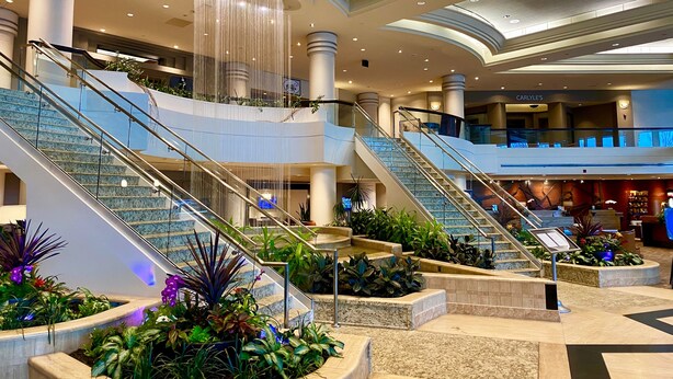 A multi-level atrium with glass railings, marble flooring, and a central water feature. - Hilton East Brunswick Hotel & Executive Meeting Center (East Brunswick)