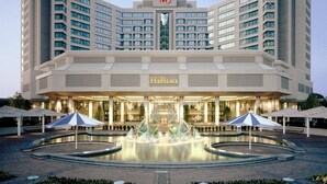 A large, modern hotel with a central fountain, multiple floors, and a well-lit entrance. - Hilton East Brunswick Hotel & Executive Meeting Center (East Brunswick)