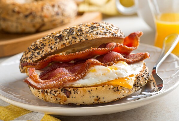 A breakfast sandwich on a plate with a fork.
