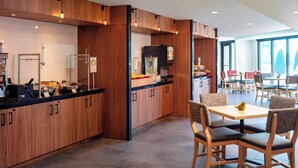 Une cuisine moderne avec des meubles en bois, un îlot central et un coin repas comprenant des chaises et une table.