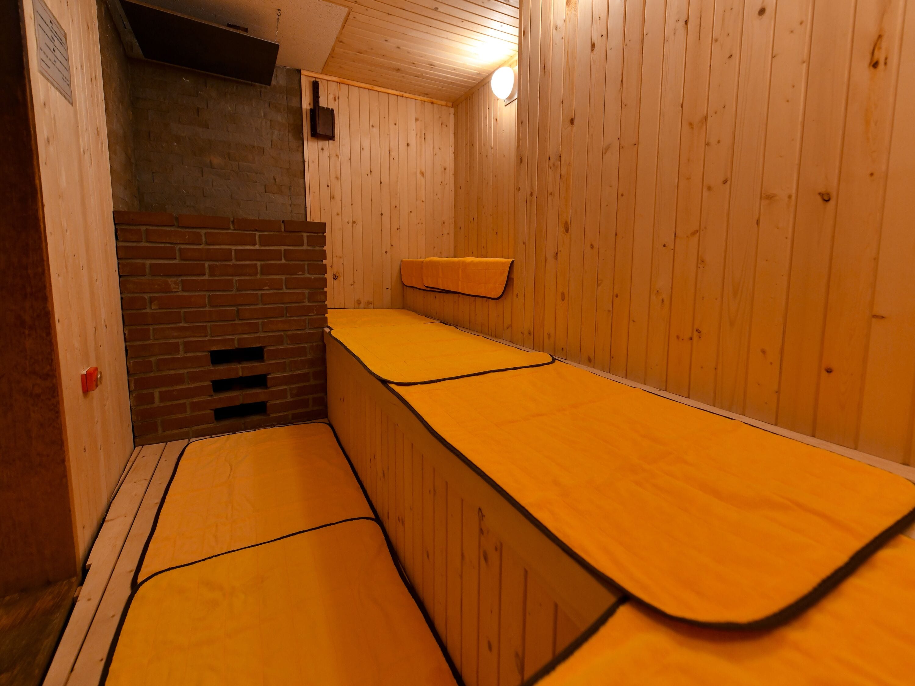 A sauna room with wooden walls and benches.