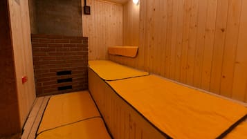 A sauna room with wooden walls and benches.