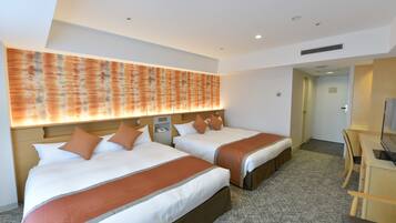 A hotel room with two beds, a desk, and a television.