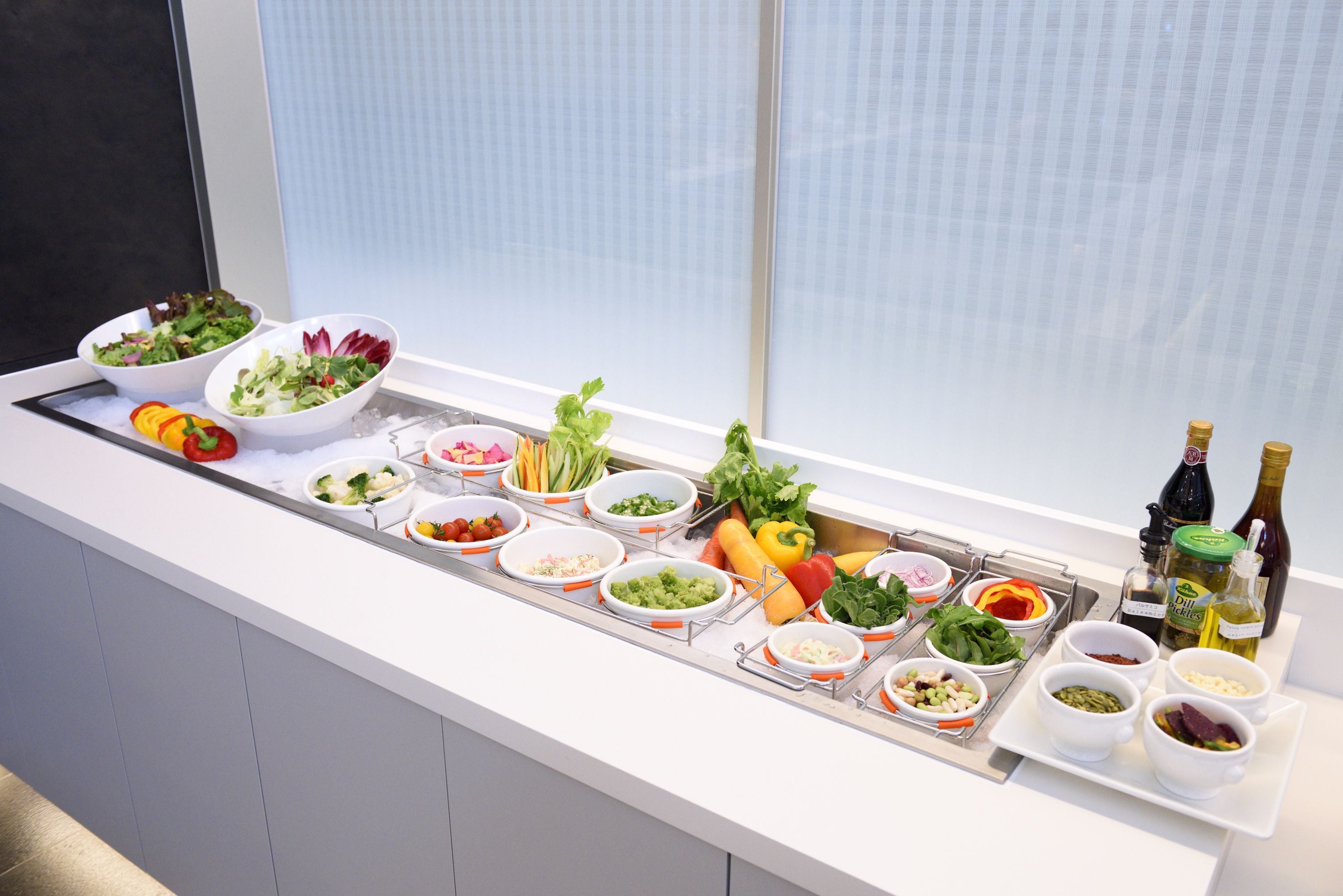 A buffet setup with various food items and condiments.