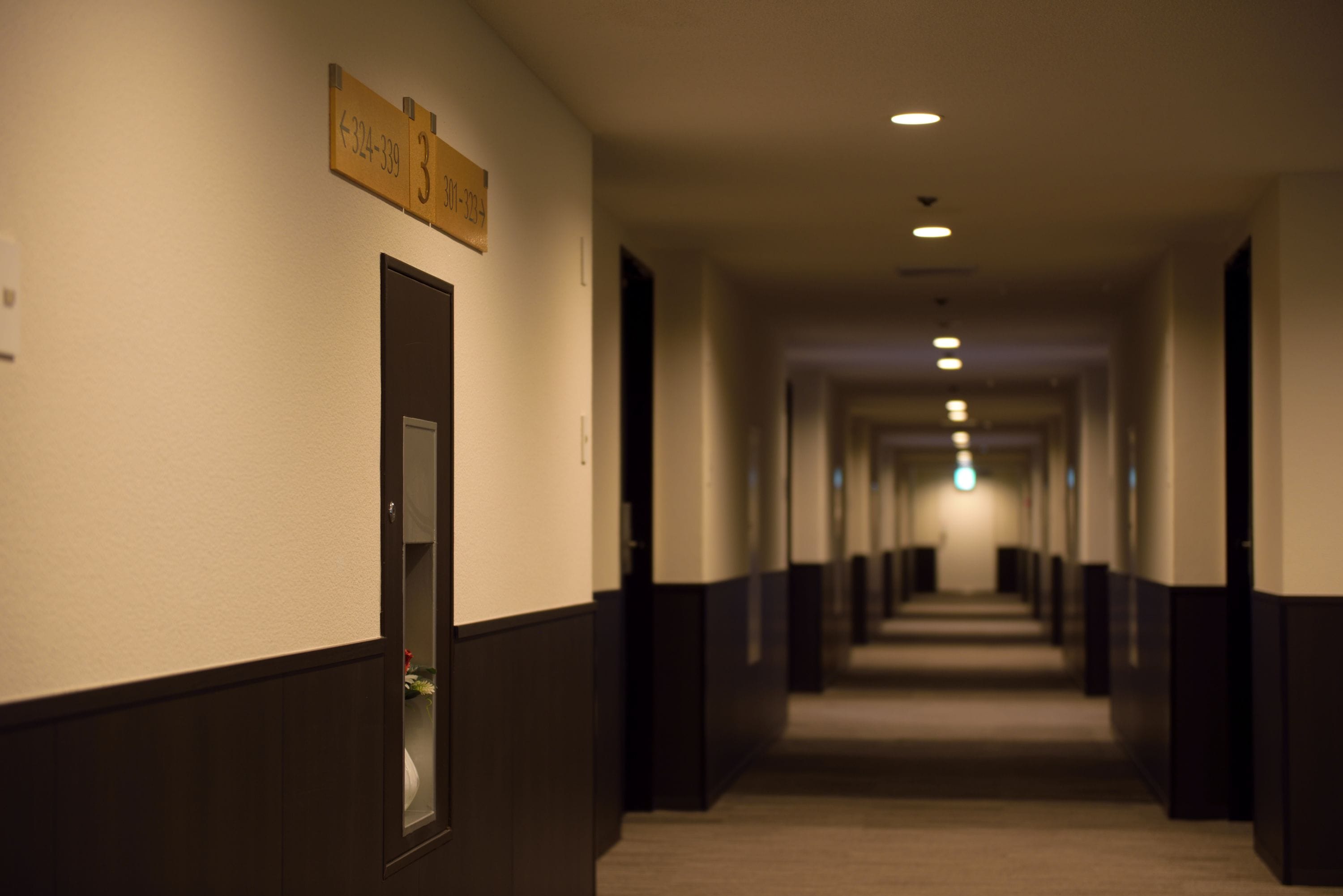 A hotel hallway with a sign indicating room number 3.
