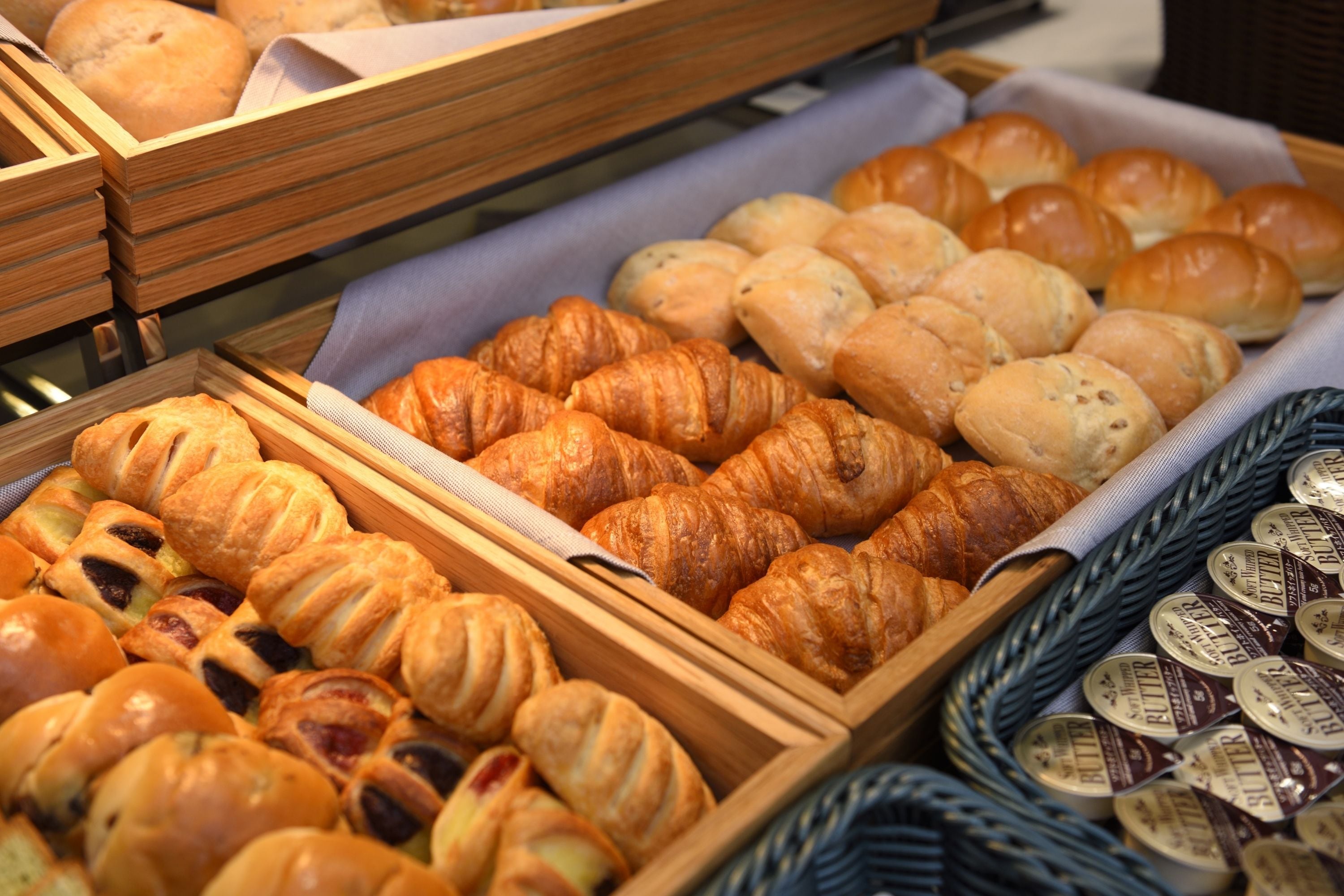 A bakery display with various types of bread and pastries.