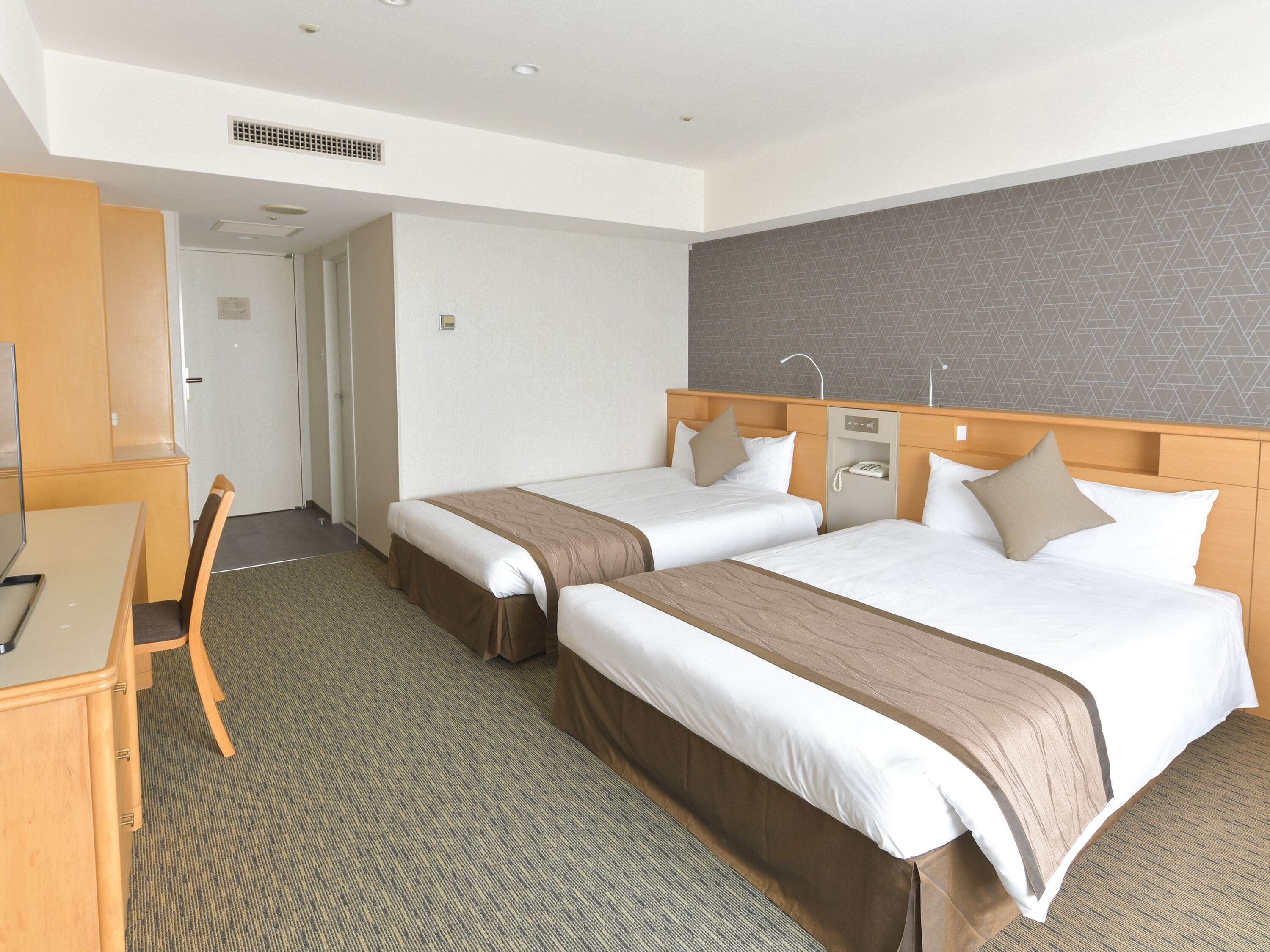 Hotellihuoneessa on kaksi sänkyä, työpöytä ja tuoli. Huoneesta on ovi toiseen huoneeseen.