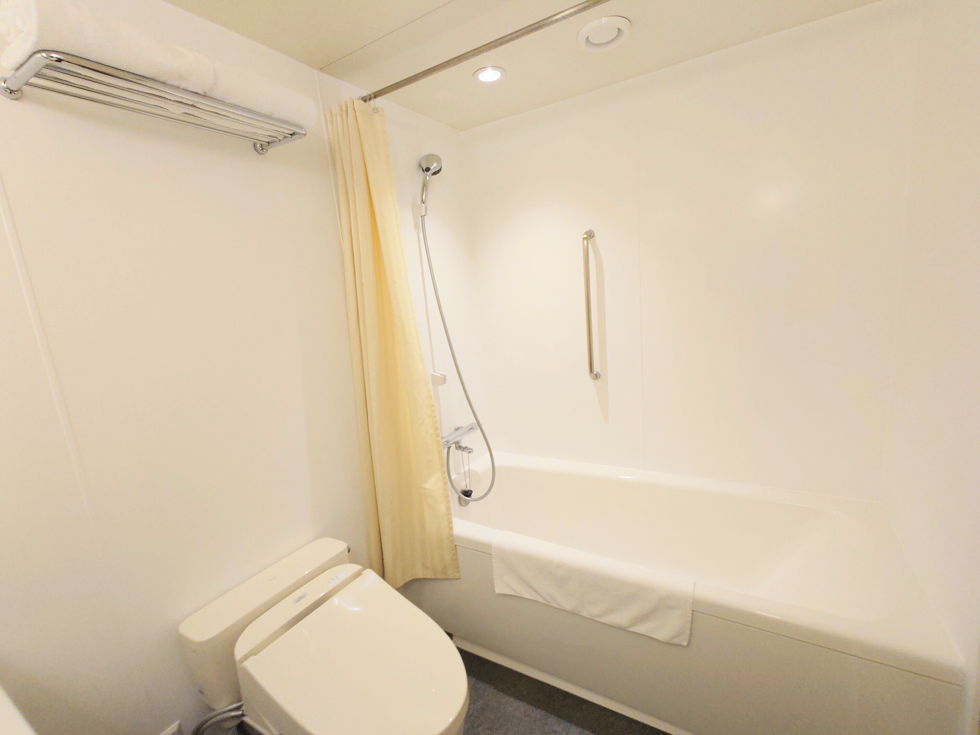 A small, clean bathroom with a toilet, a shower, and a bathtub.
