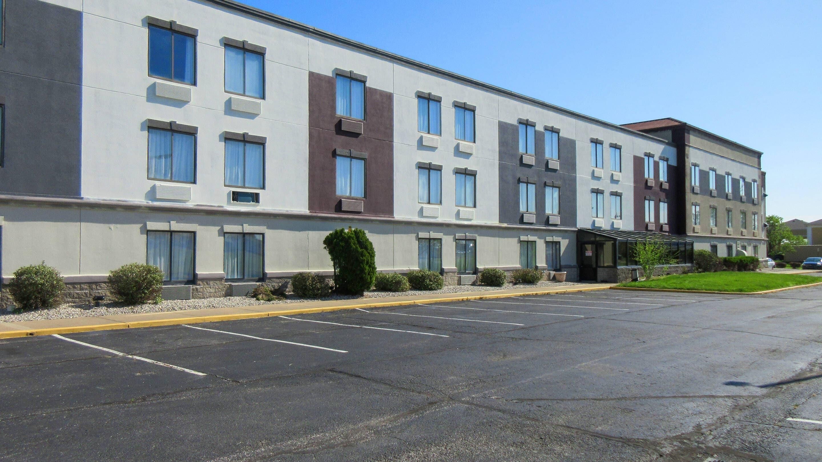 A multi-story hotel with a parking lot in front.