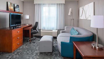 Escritorio, cortinas blackout y tabla de planchar con plancha