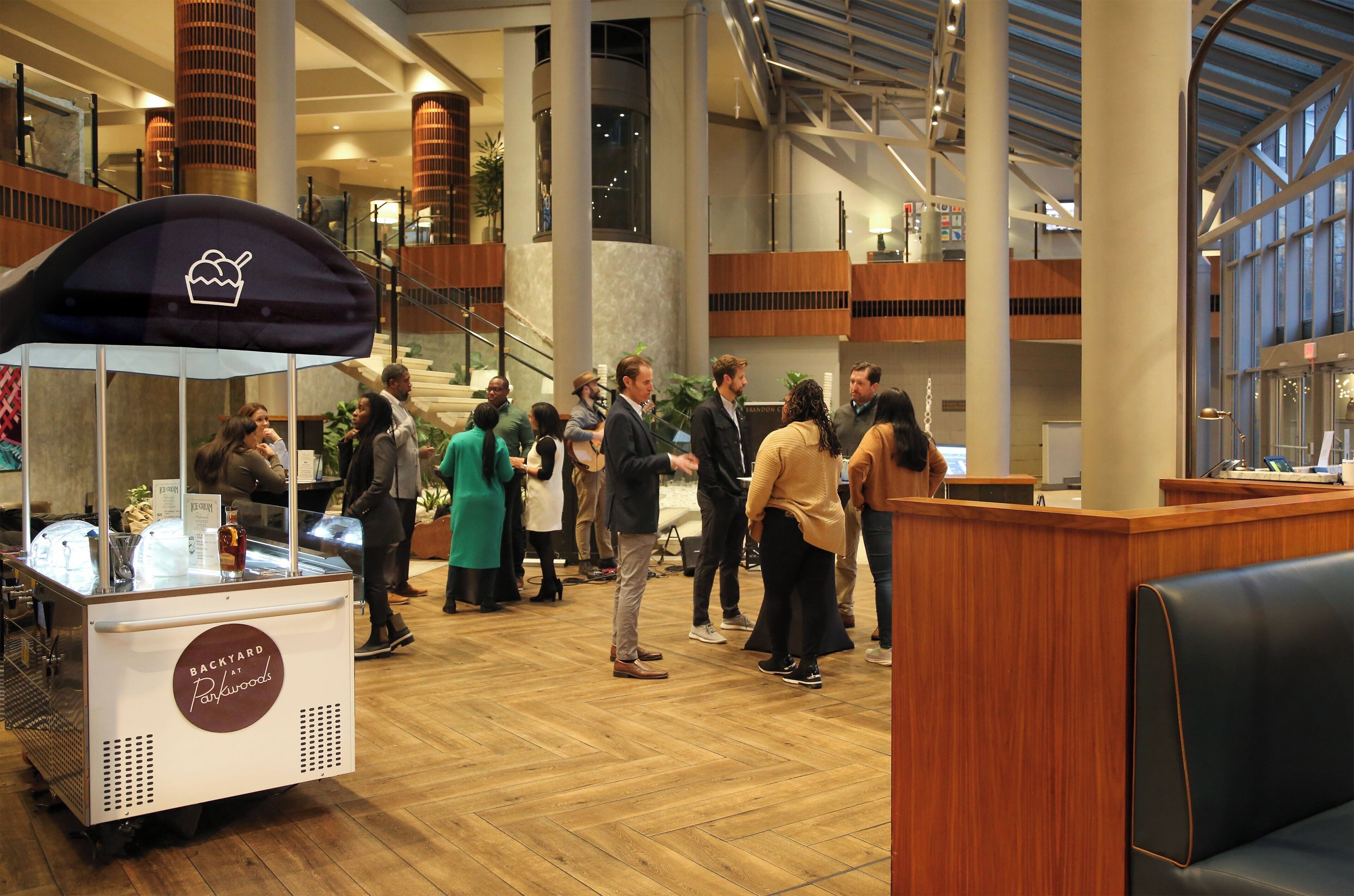 A spacious indoor area with a food cart labeled "Backyard at Panauros" and a seating area with a wooden bench.
